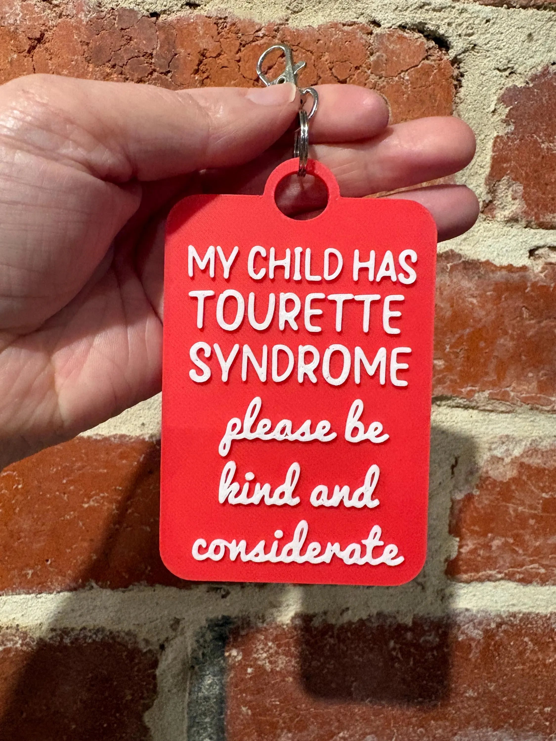 'My Child Has Tourette Syndrome' Talkies Awareness Tag - Coloured Background with White Text
